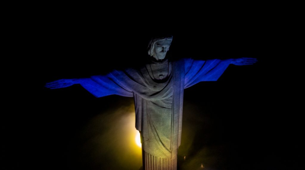Cristo Redentor é iluminado de azul e amarelo em homenagem a Barbados